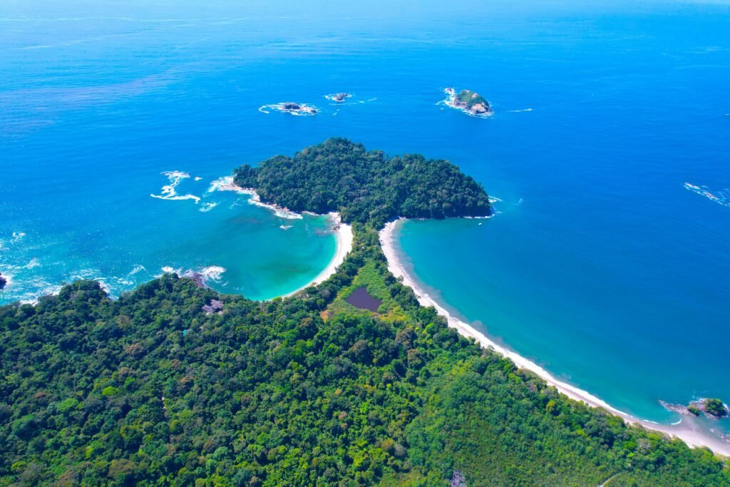 pexels-photo-13501101-13501101 Stunning aerial shot of the lush coastline and turquoise waters of Manuel Antonio National Park, Costa Rica.