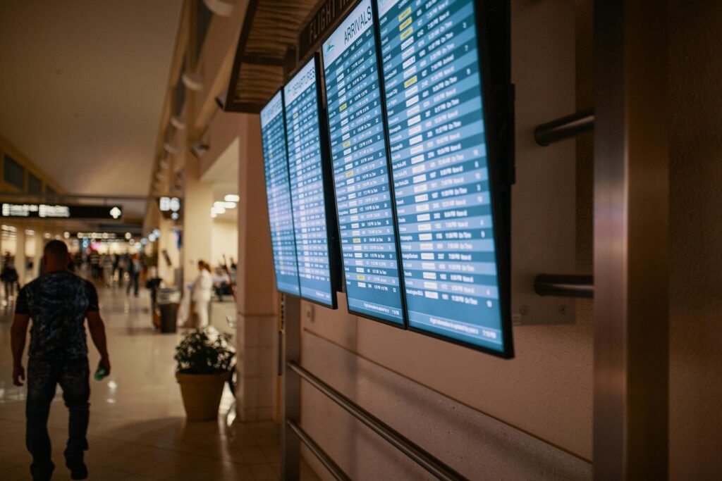 pexels-photo-1716825-1716825 Airport terminal with digital flight information boards showing arrivals and departures.