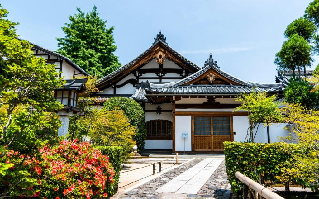 A serene traditional Japanese temple surrounded by lush gardens under clear daylight featured in a 2 week Japan itinerary.