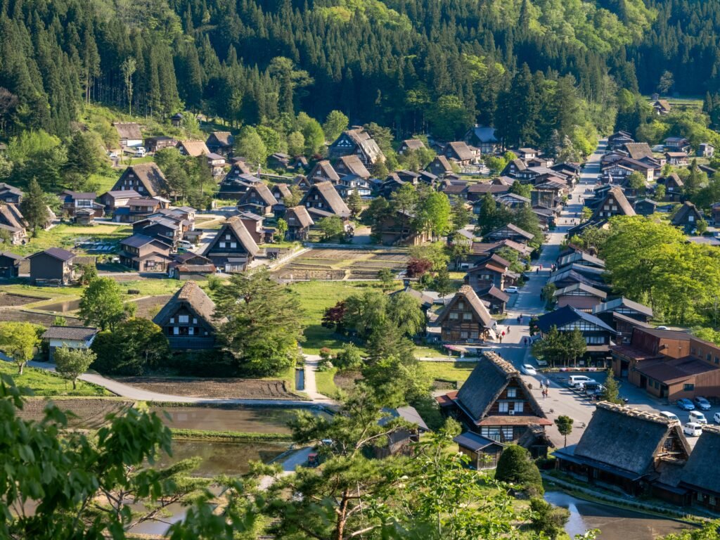 Discover Shirakawa-go, a UNESCO heritage site with iconic gassho-zukuri thatched-roof houses in a lush summer landscape.