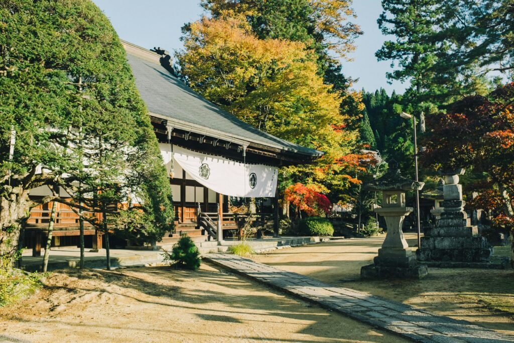 Peaceful Buddhist temple set against vibrant fall colors in Takayama, Japan.