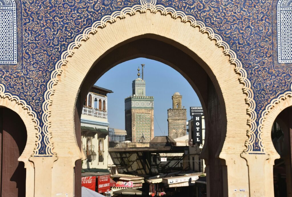 A view through Bab Bou Jeloud archway in Fès, revealing the city's historic architecture and skyline.