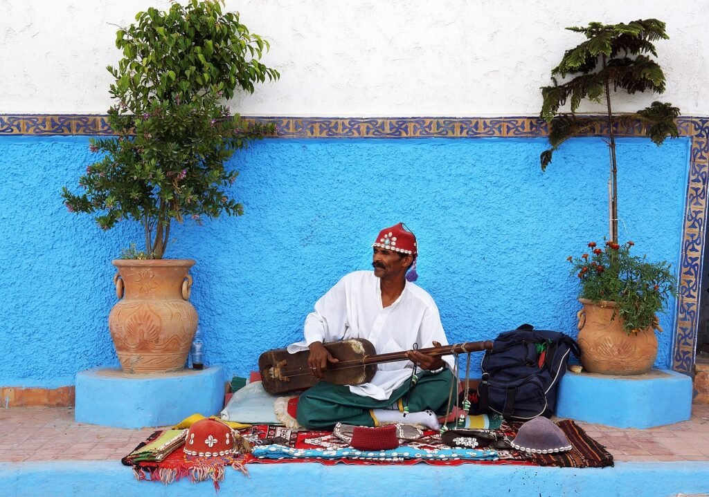 Moroccan Gnawa street performer playing a guembri in a traditional market