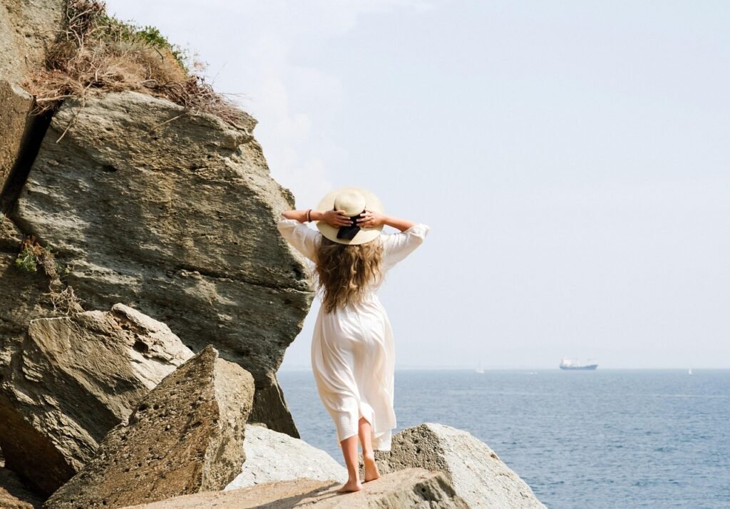Woman enjoying the scenic coastline at Punta Bianca Beach, Ameglia, Italy
