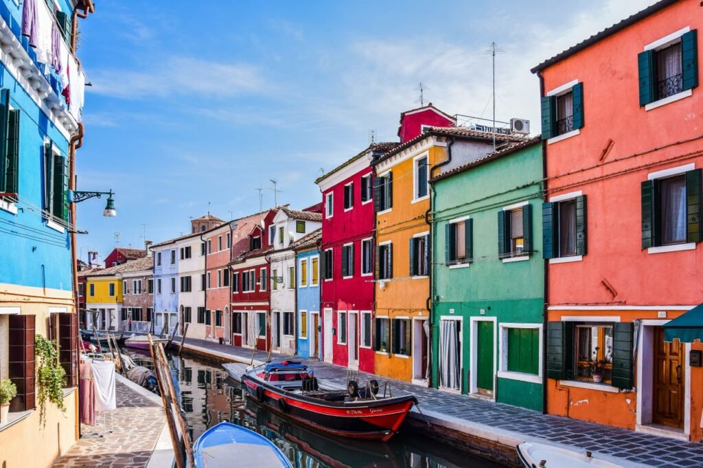 Brightly colored houses along a canal in Murano, near Venice, Italy. A must-visit travel spot.