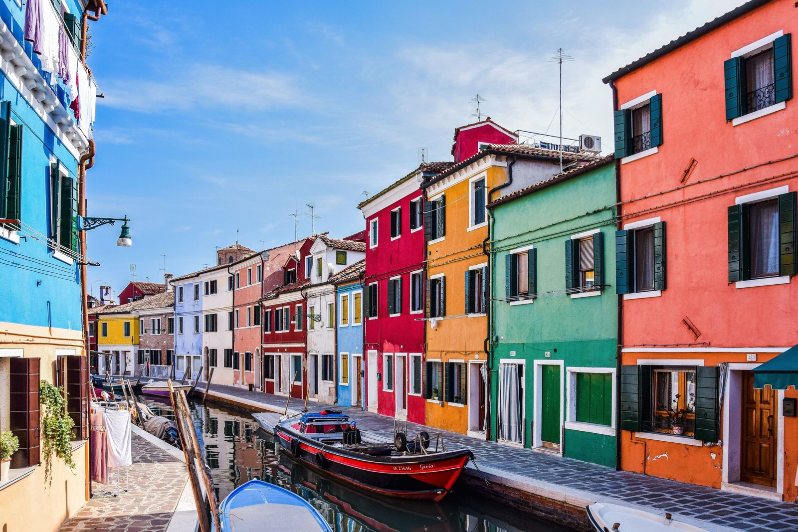 Brightly colored houses along a canal in Murano, near Venice, Italy. A must-visit travel spot.