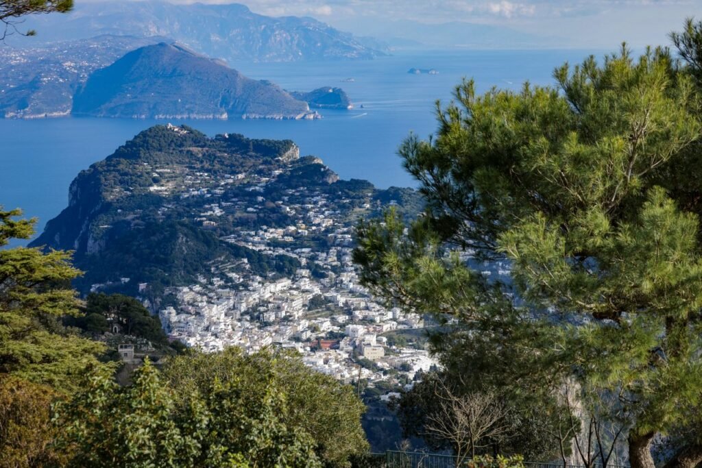 A breathtaking aerial view of Capri island with lush greenery and the Mediterranean coastline.