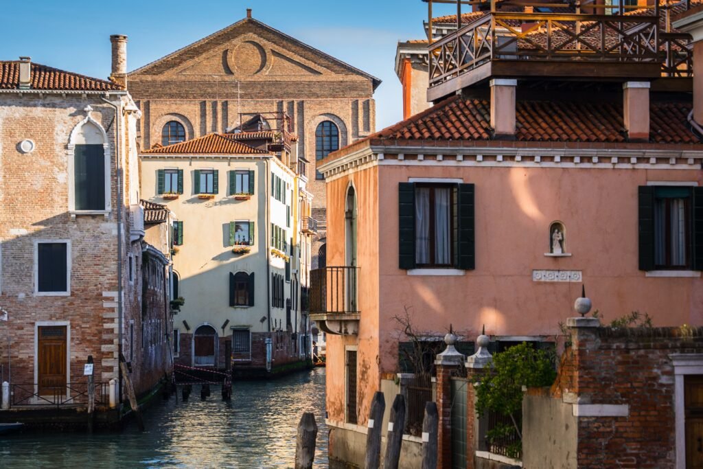 Picturesque canal scene in Venice showcasing historic architecture with warm sunlight.