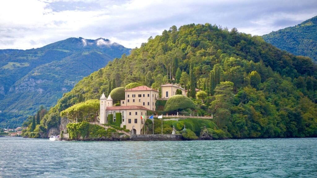 Scenic view of Villa del Balbianello nestled on Lake Como surrounded by lush greenery.