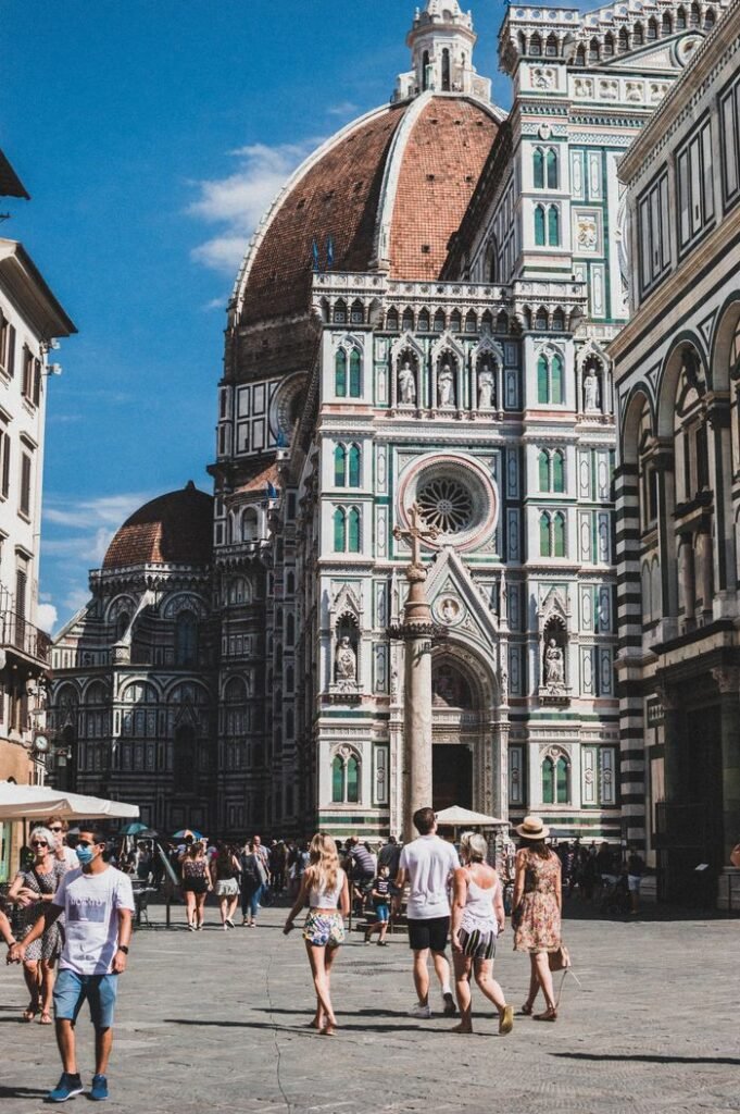 Tourists exploring the iconic Florence Cathedral in a vibrant summer setting.