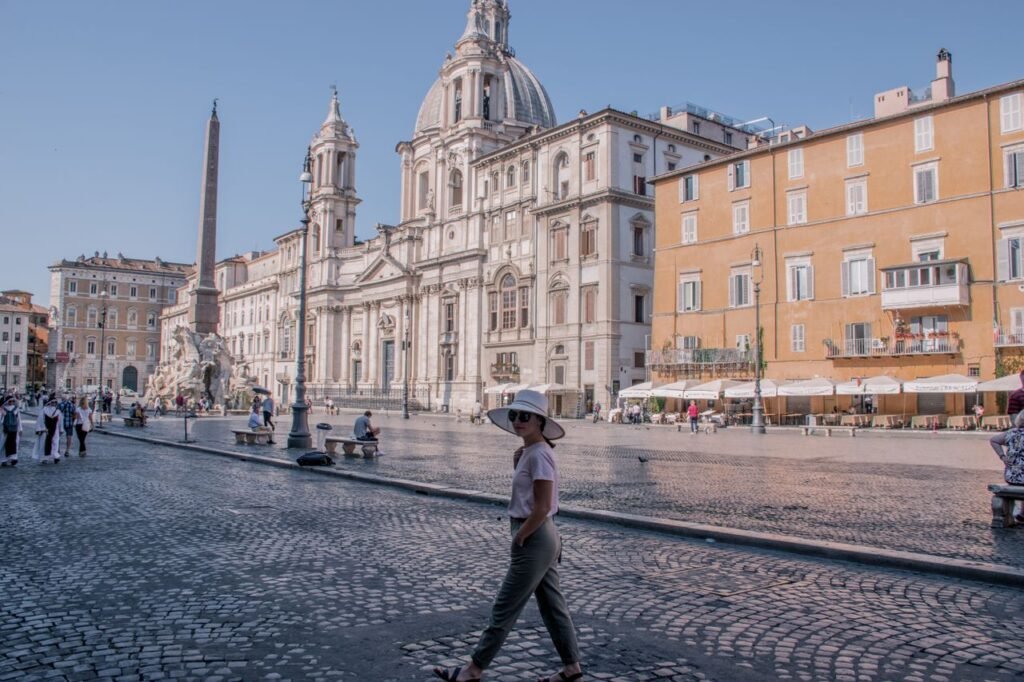 Captivating view of Piazza Navona with tourists enjoying a sunny day in Rome, Italy. It's ideal for a 7 day italy itinerary.