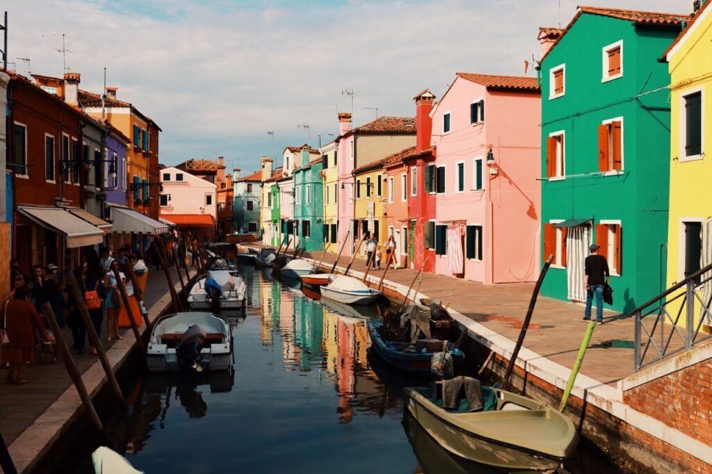 Scenic view of Burano's vibrant canal with colorful houses and boats in Venice, Italy.