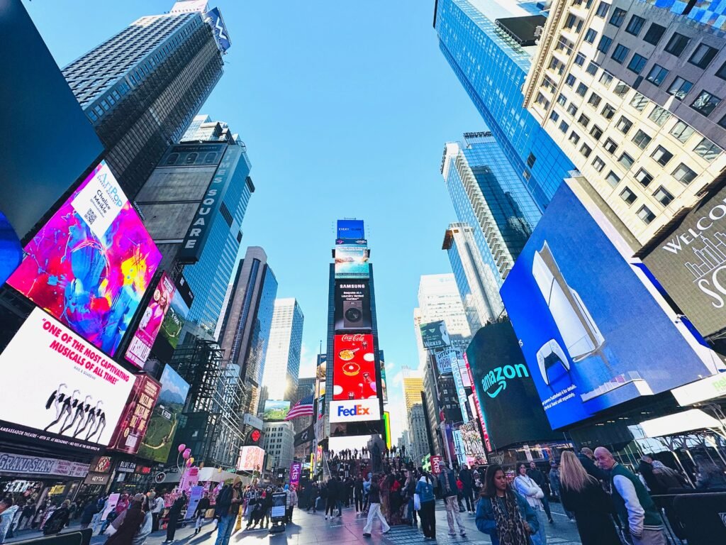 Vibrant daytime view of Times Square, showcasing iconic billboards and bustling crowd in New York City. Ideal place to visit during a 7 day New York city itinerary