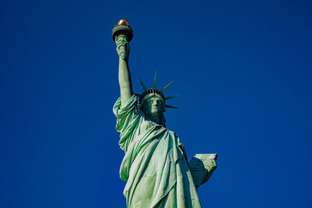 Iconic Statue of Liberty with a majestic blue sky backdrop, symbol of freedom in New York City.