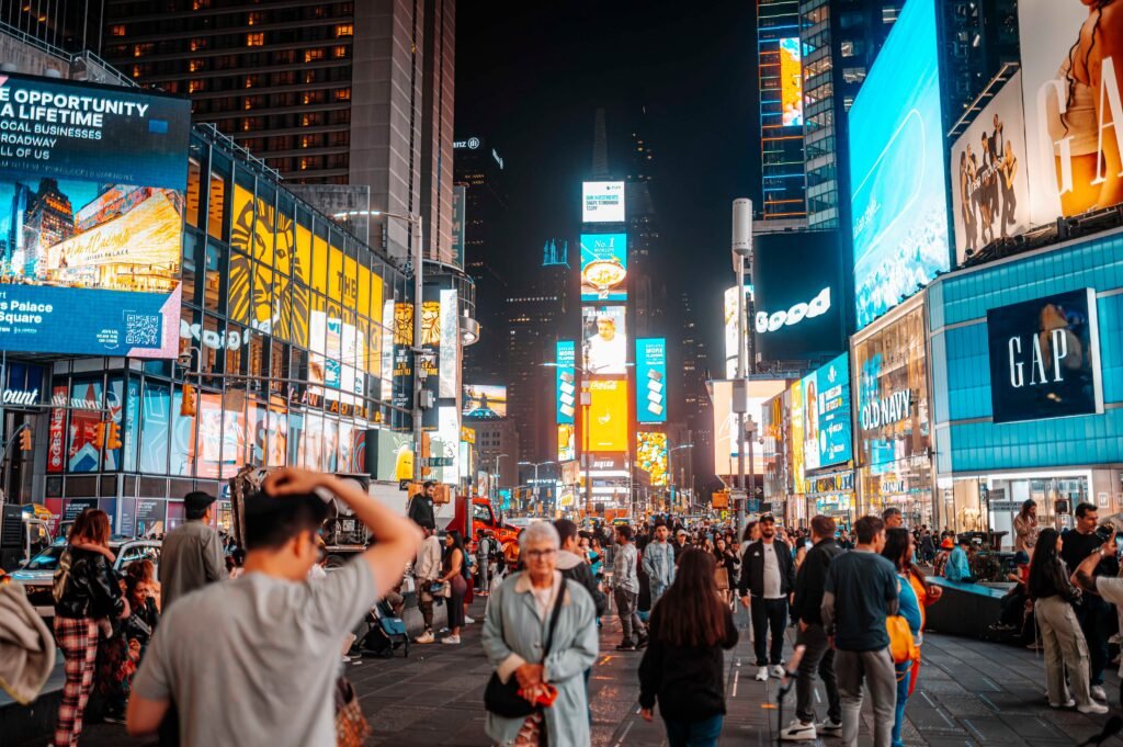 Capture of bustling Times Square at night, showcasing iconic billboards and a lively crowd.