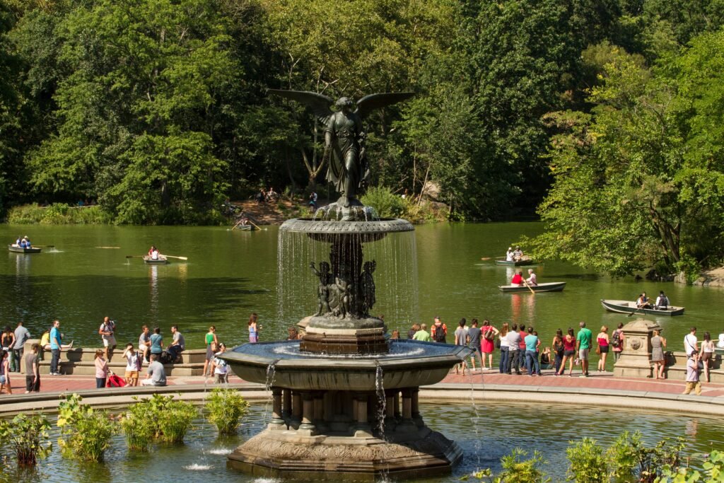 Iconic Bethesda Fountain with people and boats in Central Park, NYC